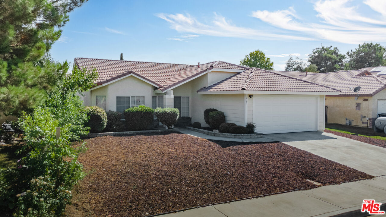 716 East E Avenue Lancaster, CA 93535 - Photo 1 of 17 a view of a house with a small yard and large tree