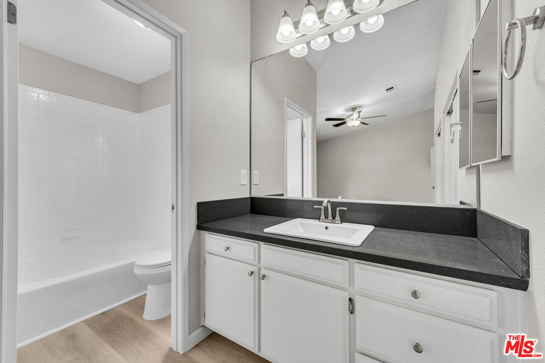 716 East E Avenue Lancaster, CA 93535 - Photo 11 of 17 a bathroom with a granite countertop sink a toilet and bathtub
