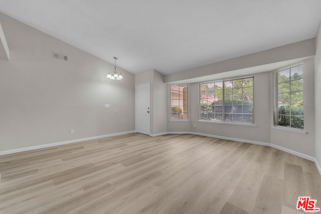 716 East E Avenue Lancaster, CA 93535 - Photo 4 of 17 a view of an empty room with wooden floor and a window