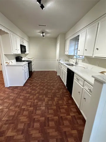 a large kitchen with kitchen island granite countertop a sink counter top space appliances and cabinets