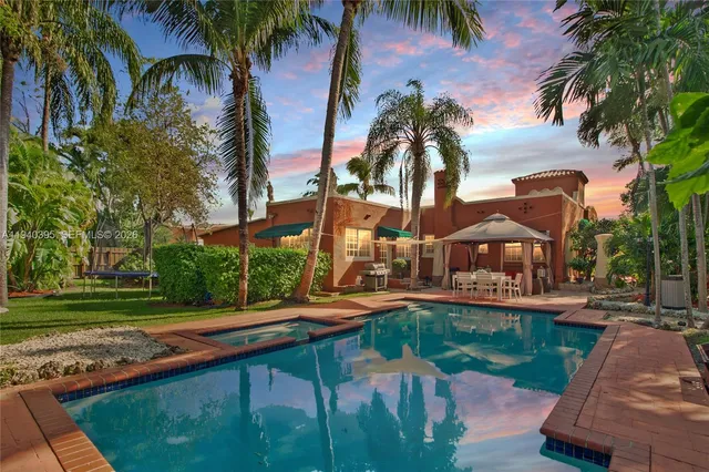 a front view of a house with garden and swimming pool