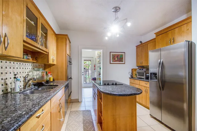 a kitchen with stainless steel appliances granite countertop a sink a stove and refrigerator
