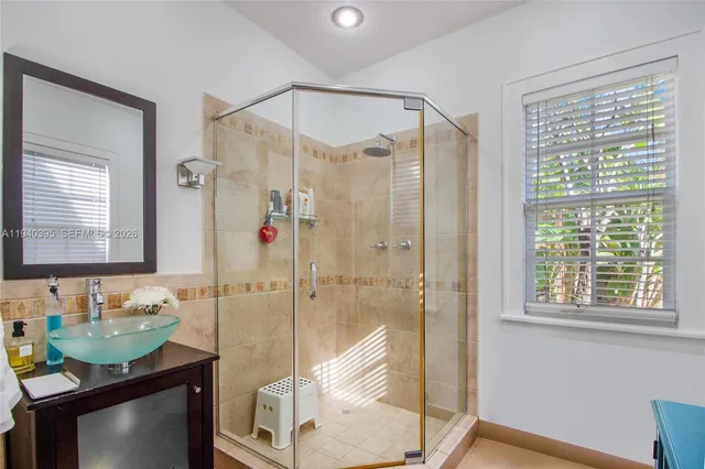 a bathroom with a shower sink vanity and mirror