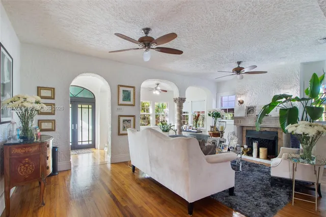 a living room with furniture fireplace and wooden floor