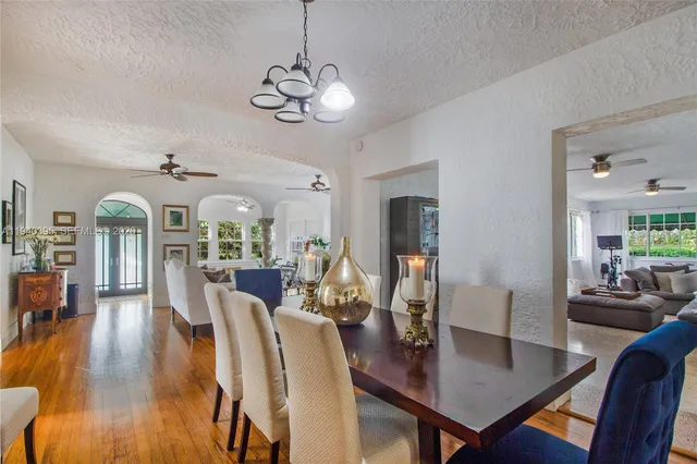 a view of a dining room with furniture a chandelier and wooden floor