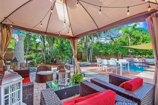 a outdoor space with patio the couches and pool table and chairs under an umbrella