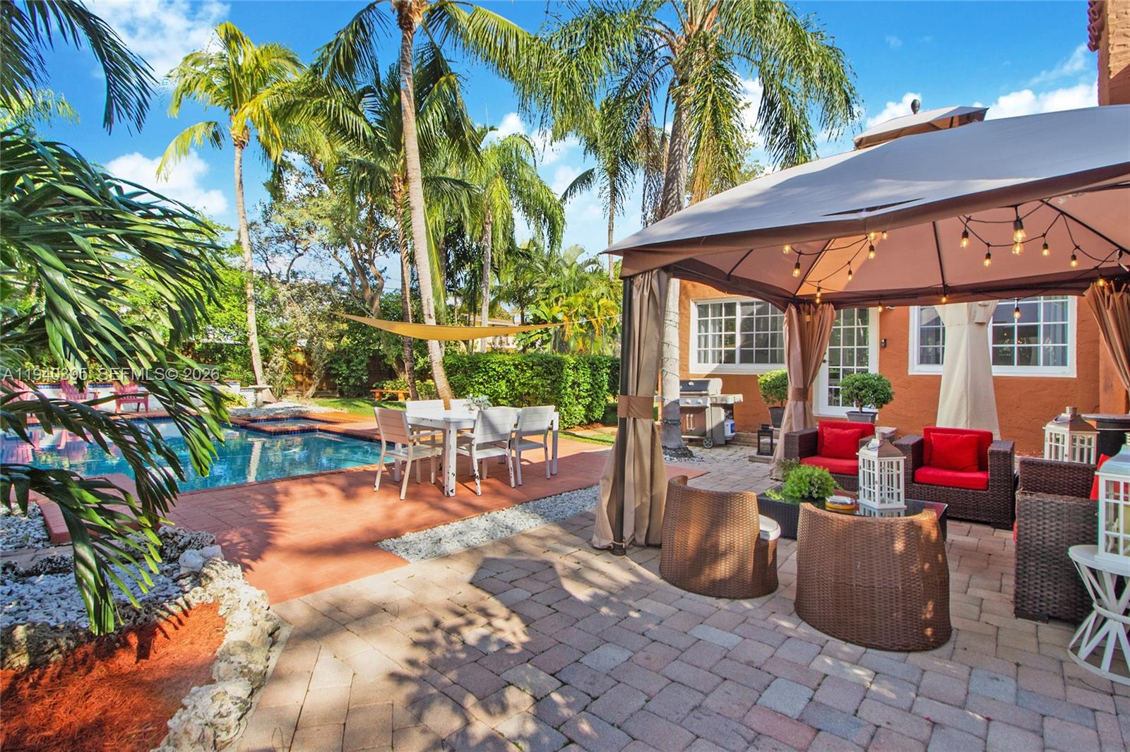 2985 Southwest 13th Street Miami, FL 33145 - Photo 8 of 27 a view of a patio with table and chairs potted plants and a large tree