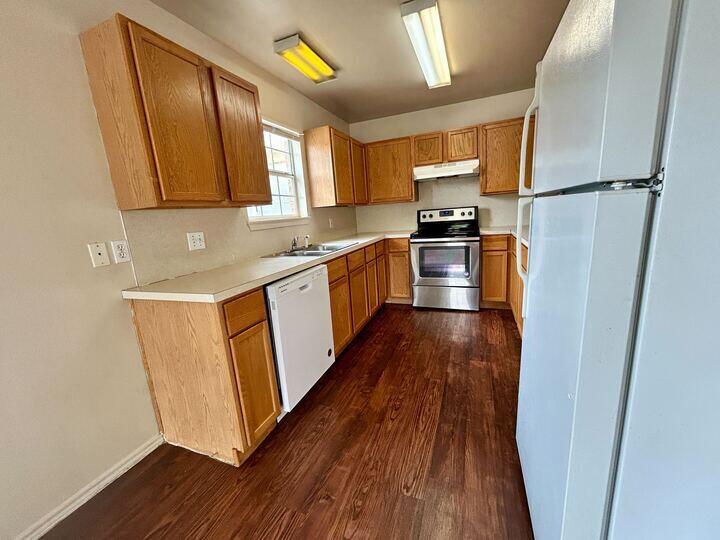1108 82nd Street, Unit A Lubbock, TX 79423 - Photo 3 of 11 a kitchen with granite countertop wooden floors and stainless steel appliances