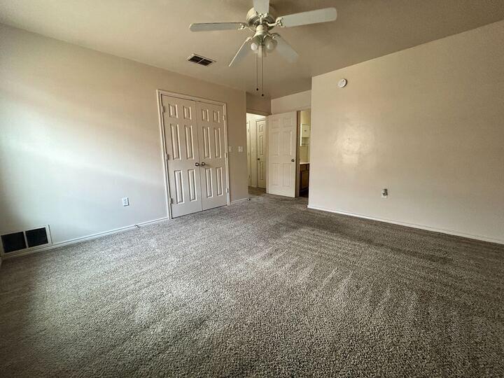 1108 82nd Street, Unit A Lubbock, TX 79423 - Photo 10 of 11 an empty room with fan and windows
