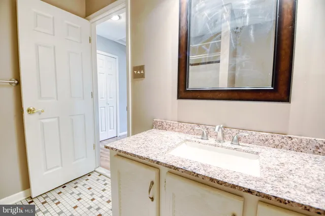 a bathroom with a granite countertop sink a toilet and shower