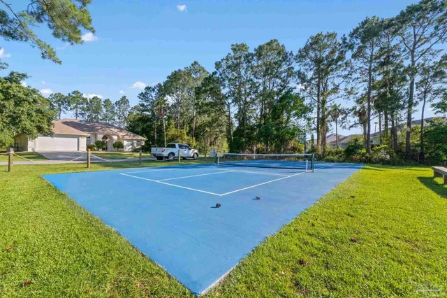 a view of a swimming pool with lawn chairs and a big yard