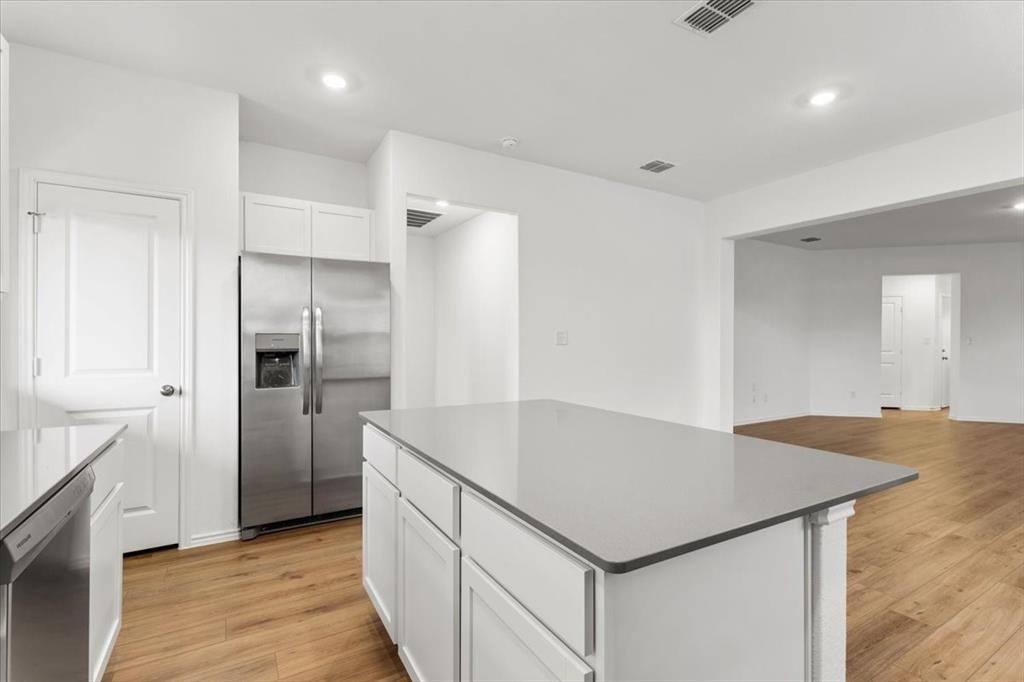487 Alamito Avenue Kyle, TX 78640 - Photo 13 of 36 a kitchen with kitchen island a refrigerator and a sink