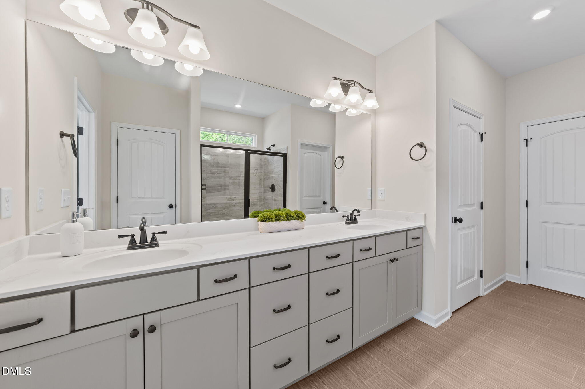 3901 Bluffwind Drive Raleigh, NC 27603 - Photo 19 of 42 a bathroom with double vanity sinks a vanity a lamp and a mirror