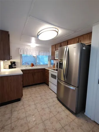 a kitchen with stainless steel appliances granite countertop a refrigerator and a sink