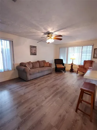 a living room with furniture ceiling fan and a window