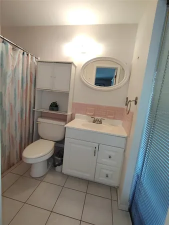 a bathroom with a toilet a sink and a mirror