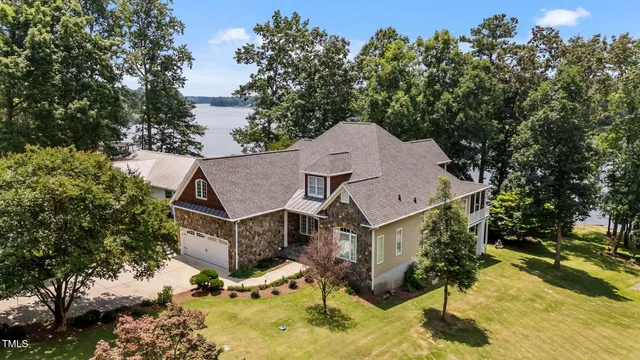 an aerial view of a house with yard patio and covered with trees