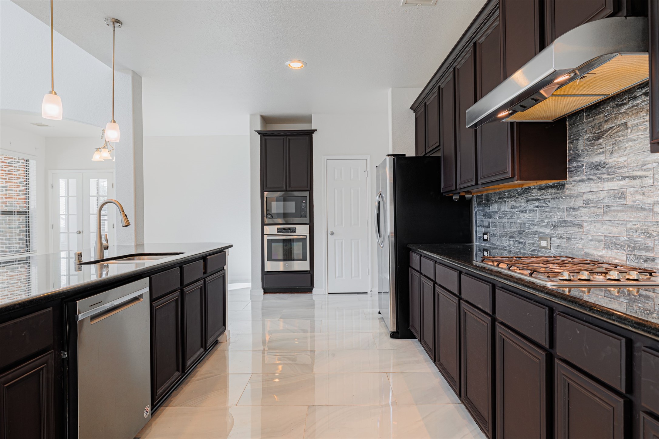 7814 Pacific Spring Lane Richmond, TX 77407 - Photo 11 of 32 a kitchen with stainless steel appliances kitchen island granite countertop a refrigerator and a sink