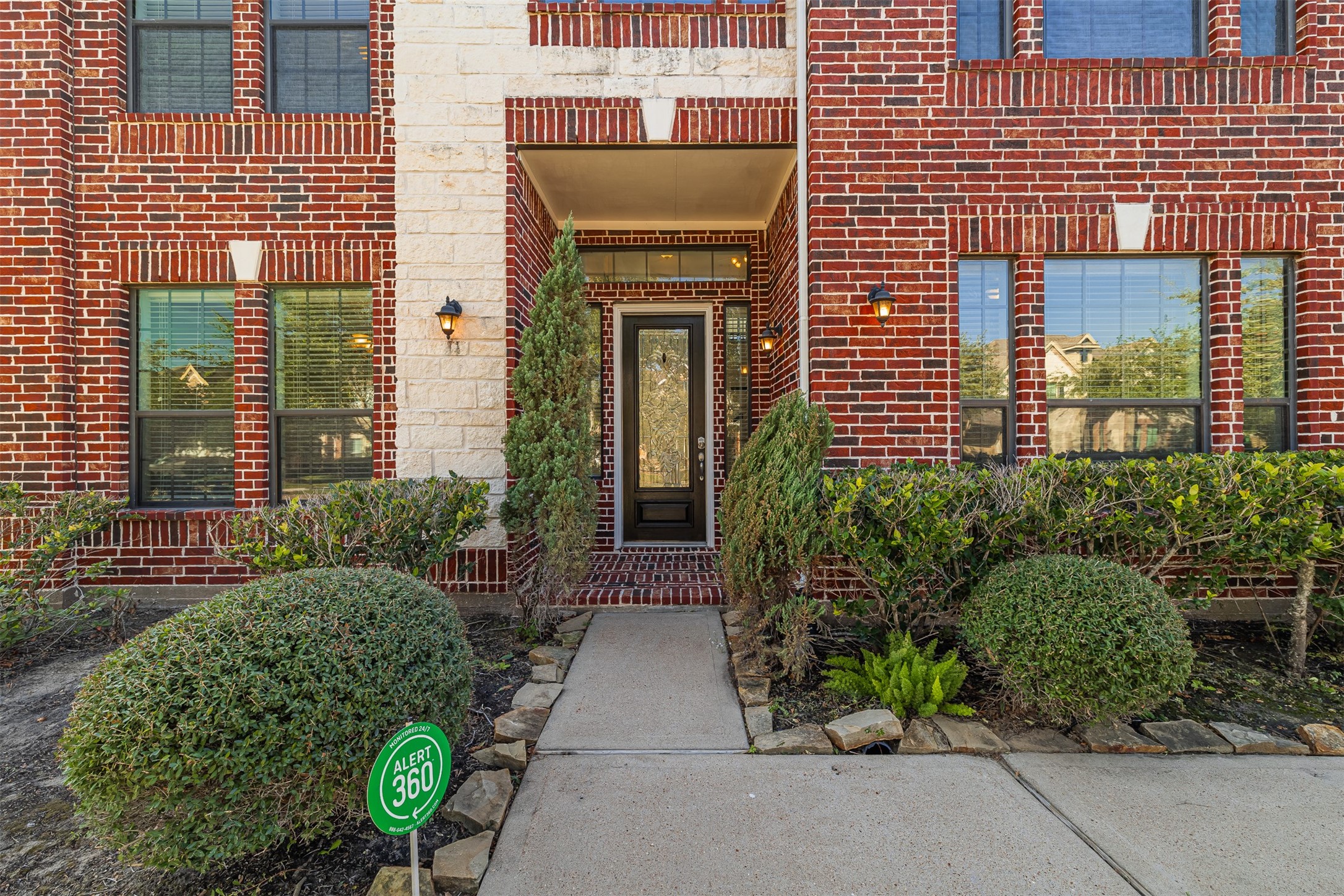 7814 Pacific Spring Lane Richmond, TX 77407 - Photo 4 of 32 a view of a house with potted plants and a bench