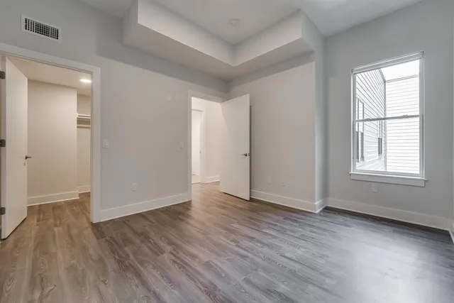an empty room with wooden floor and windows