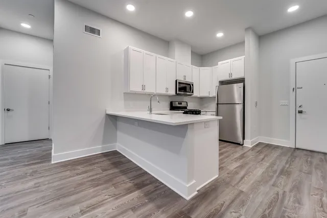 a kitchen with kitchen island white cabinets and stainless steel appliances