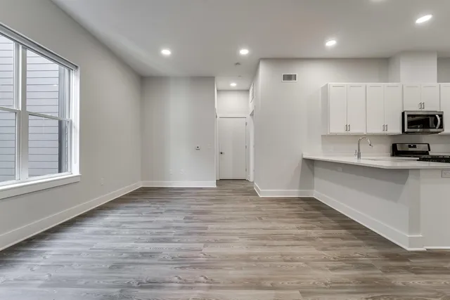 a view of kitchen with kitchen island a sink wooden floor and a refrigerator