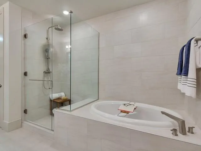 a bathroom with a tub a sink and a shower