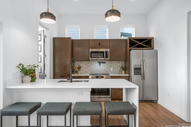 a kitchen with a table chairs refrigerator and microwave