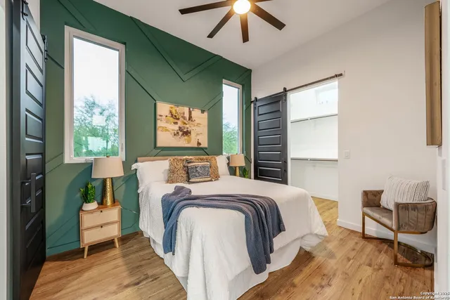 a bedroom with a bed wooden floor and window