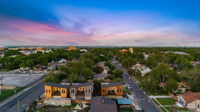 an aerial view of residential houses with outdoor space and street view