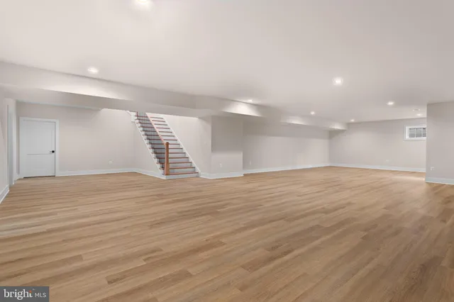 a view of an empty room with wooden floor and a yard