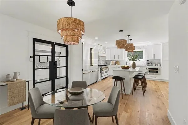 a dining room with furniture a chandelier and wooden floor