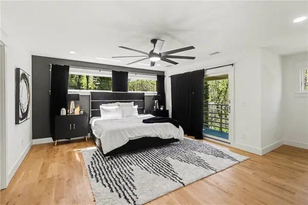 a bedroom with a bed lamp and a large window