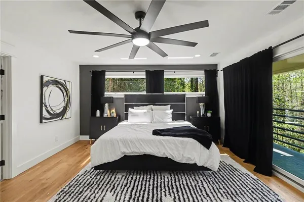 a bedroom with a bed a mirror and a window