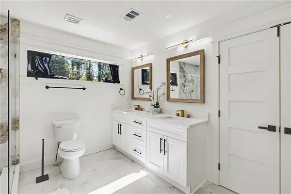 a bathroom with a toilet a sink and a mirror