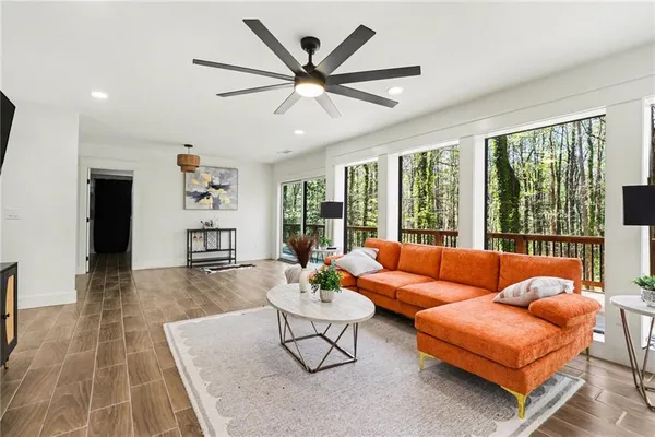 a living room with furniture and a large window with wooden floor