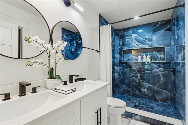 a bathroom with a sink a toilet and a mirror