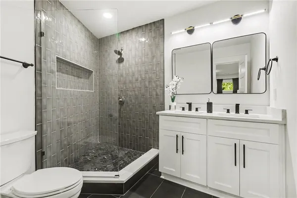 a bathroom with a sink a toilet and shower
