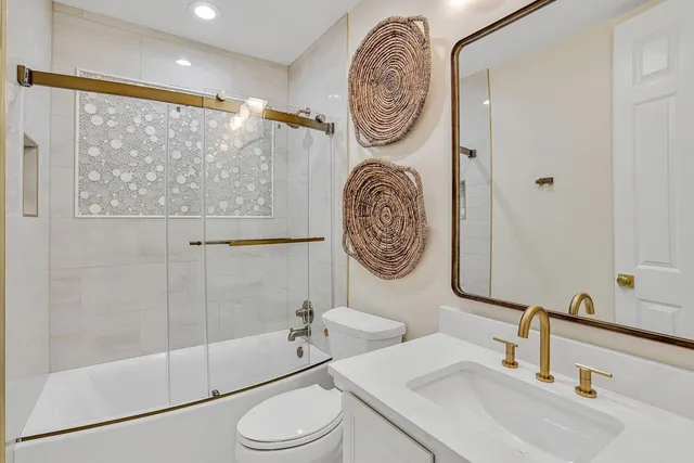 a bathroom with a tub a sink and a large mirror