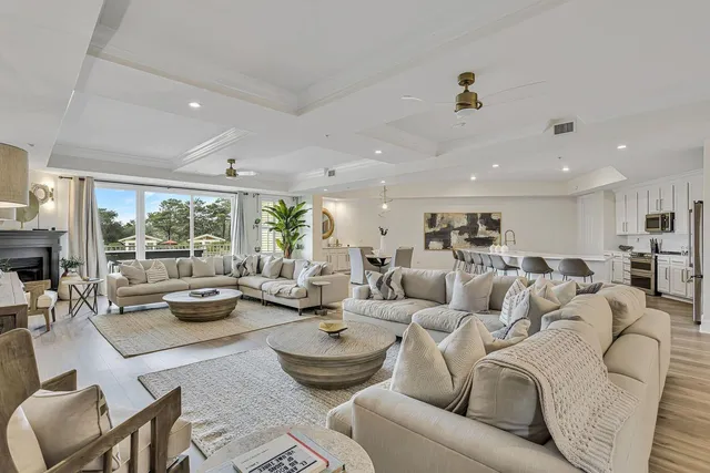 a living room with furniture white walls and kitchen view
