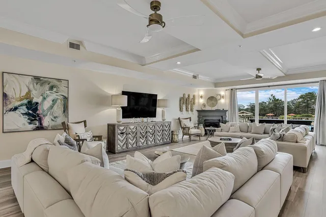 a large white kitchen with stainless steel appliances granite countertop a stove a sink dishwasher and white cabinets with wooden floor