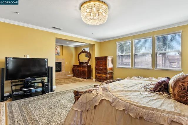 a spacious bedroom with a bed and a chandelier