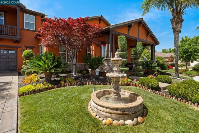 a backyard of a house with a fountain table and chairs