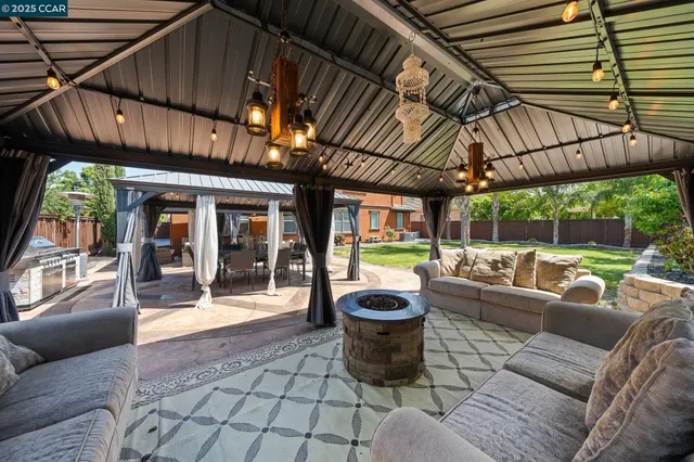 a view of a patio with couches chairs potted plants and a palm tree