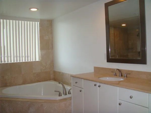 a bathroom with a granite countertop sink vanity and mirror