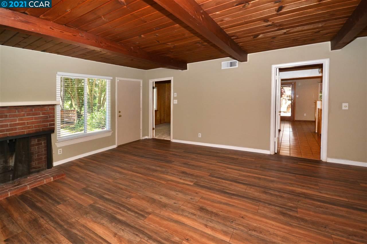 928 Janet Lane Lafayette, CA 94549 - Photo 9 of 35 a view of an empty room with wooden floor fireplace and a window
