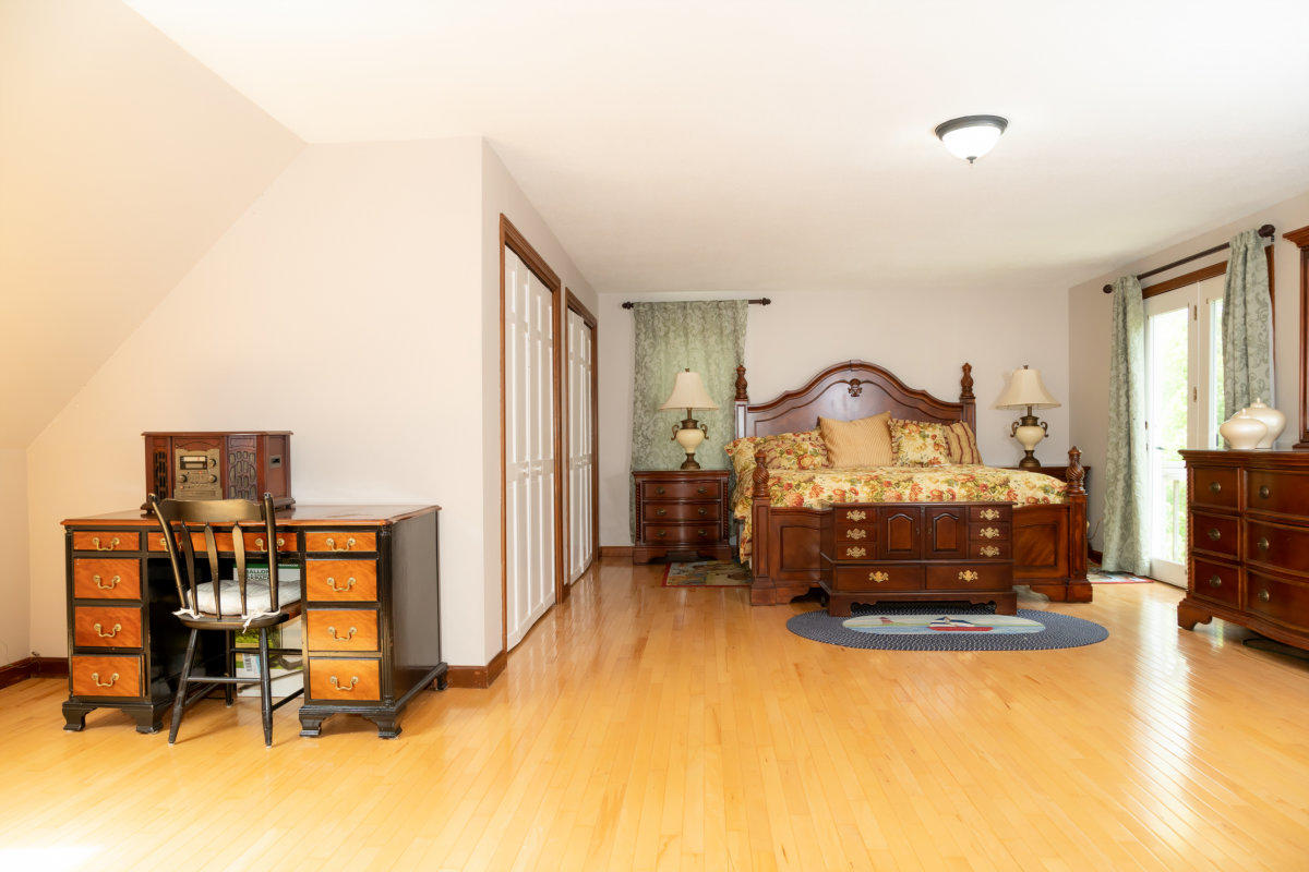 636 Lumbert Mill Road Centerville, MA 02632 - Photo 13 of 23 a bedroom with a bed and a chandelier