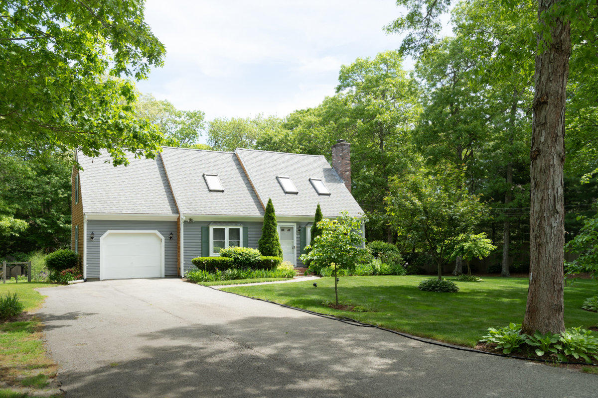 636 Lumbert Mill Road Centerville, MA 02632 - Photo 2 of 23 a front view of a house with a yard and trees