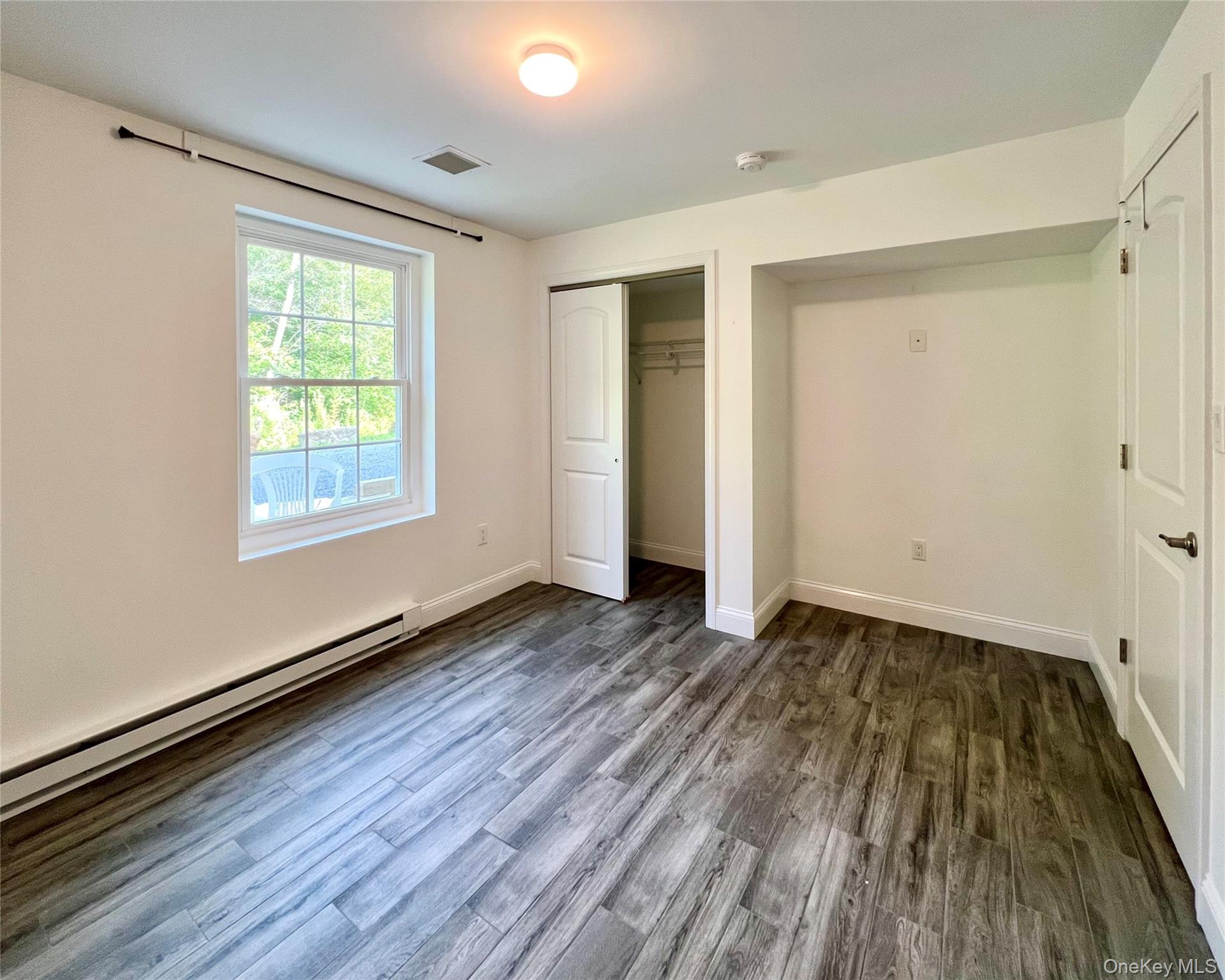 16 Albano Ridge, Unit 1 Carmel, NY 10512 - Photo 4 of 6 a view of an empty room with wooden floor and a window