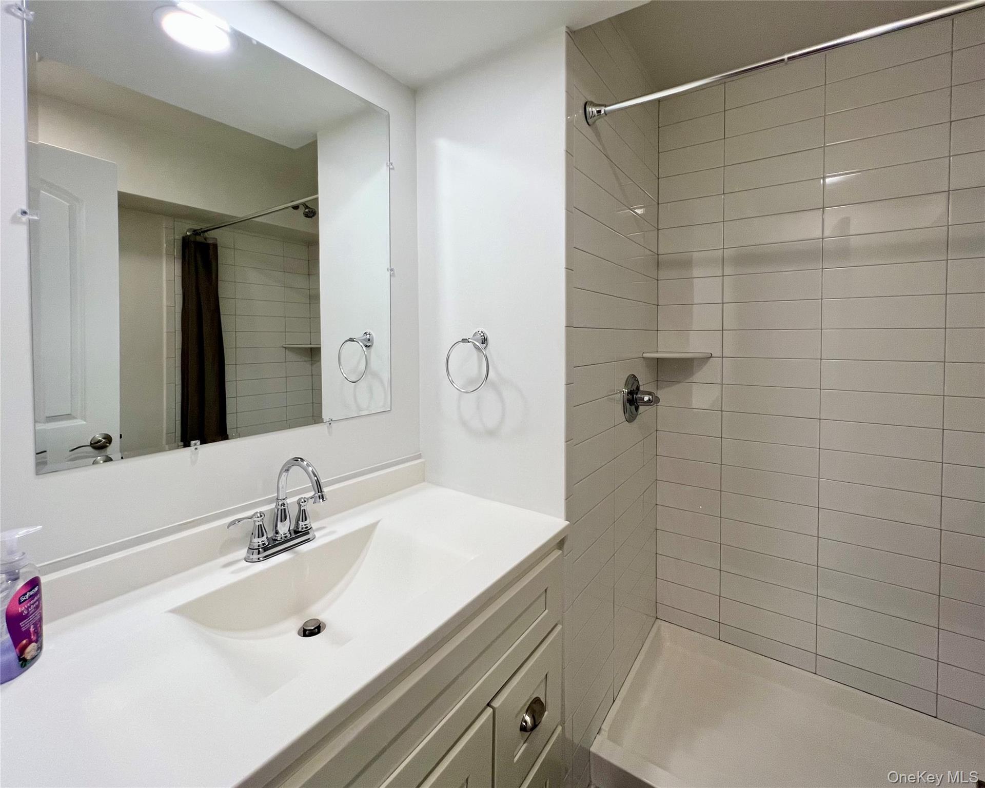 16 Albano Ridge, Unit 1 Carmel, NY 10512 - Photo 5 of 6 a bathroom with a sink a shower and a mirror
